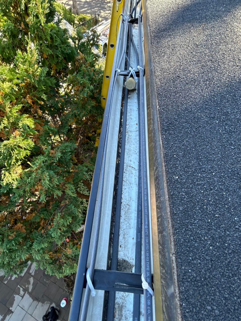 Top-down view of heavy-duty commercial gutter heat tracing and cable channel routing.