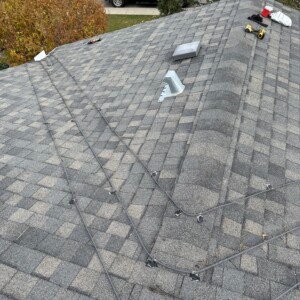 Custom V-pattern roof heating cable layout on a shingled hip roof ridge.
