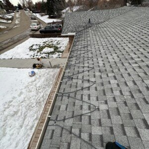 Symmetrical serpentine roof edge heating cable array installed on an asphalt shingle roof profile.