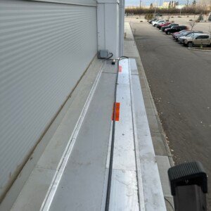 Commercial flat roof de-icing cable system installation overlooking a corporate property parking lot in Calgary.
