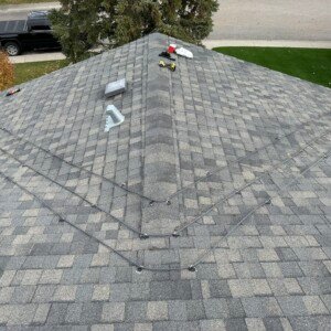 Full view of a residential hip roof de-icing cable system installation in a Calgary neighborhood.